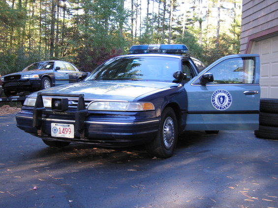 Massachusetts State Police car with door open, another police car behind it