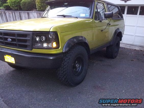 Yellow 1992 Ford Bronco 3/4 front view with aftermarket headlights
