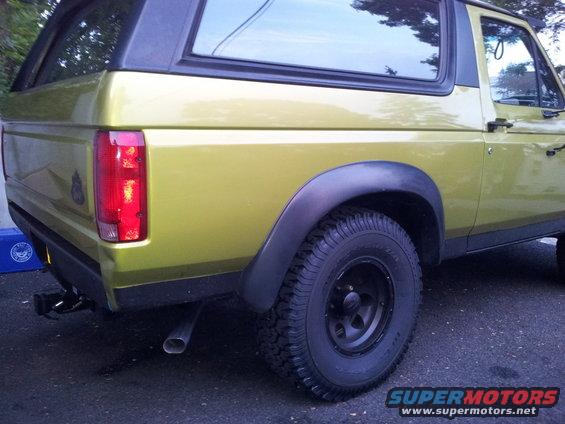 Rear quarter view of a 1992 Ford Bronco, yellow-green paint, black fender flares, and black wheels