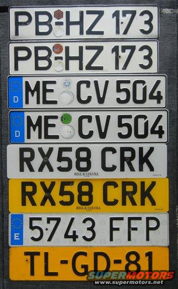 Stack of license plates with various markings and numbers