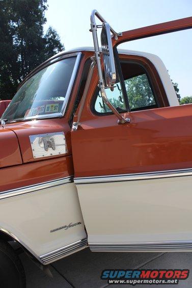 Side view of a two-tone orange and cream pickup truck. Chrome trim and side mirror visible