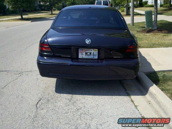 dark sedan parked on street, rear view. License plate says MGM 6P