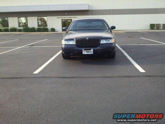 Dark blue Mercury Grand Marquis parked in a lot, front view. License plate reads MGM 6