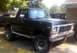 1979 Ford Bronco - This black Ford Bronco is parked outdoors next to a building.