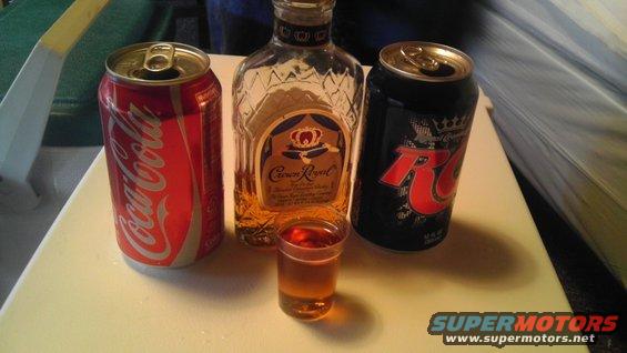 Coca-Cola, Crown Royal, and RC Cola cans with a shot glass