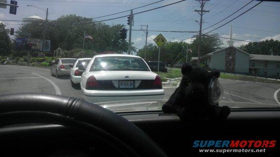 Three white sedans in traffic, front one has license plate F5X3N