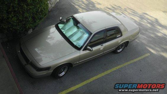 Tan 2000 Mercury Grand Marquis parked on asphalt with a yellow line