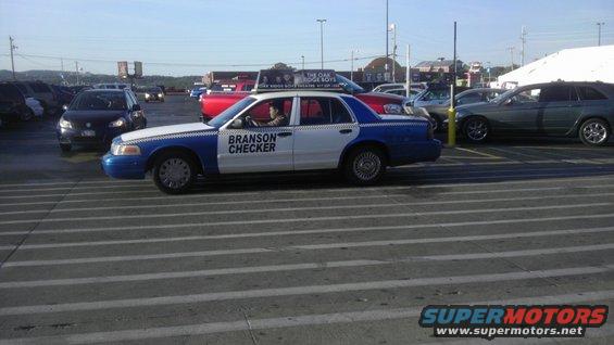 Police car with 'BRANSON CHECKER' on the side, parked in a lot