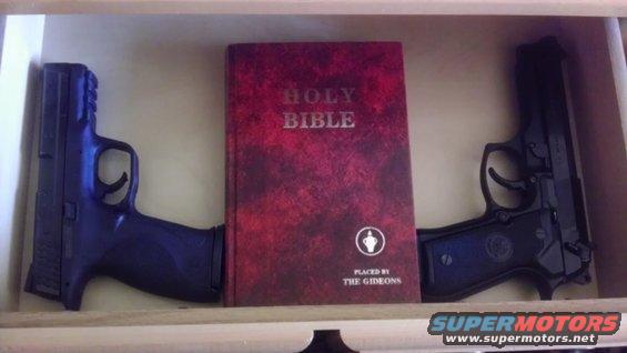 Two handguns flanking a Holy Bible placed by The Gideons