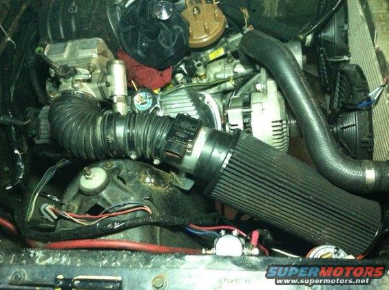 More mock-up. That intake system is not the best, but it works. I found the intake "elbows" lying around the junkyard. One of them has a chrysler part number on it...

The MAF is bolted to a bracket that I welded to the shock tower. 

The radiator is from a 80s F250. The radiator core support and front frame rails had to be "trimmed" in order to fit the radiator. E-fans came from eBay. 