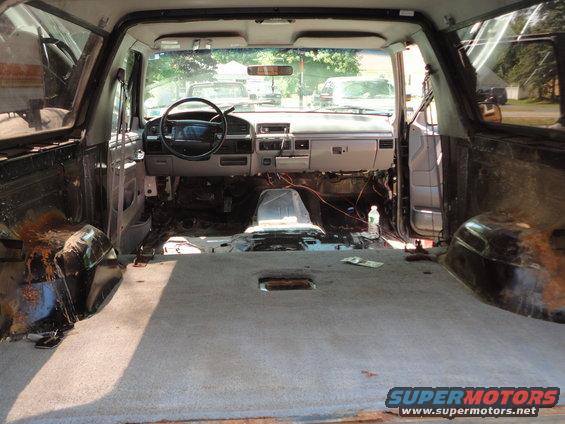Interior of a 1995 Ford Bronco with seats removed and dashboard partially disassembled
