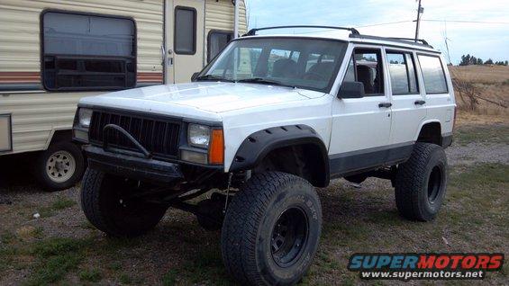1995 Jeep Cherokee with off-road tires and fender flares parked outdoors