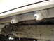 1989 Ford Bronco - Close-up view of the rusty undercarriage of a vehicle, revealing structural components and mounting brackets.