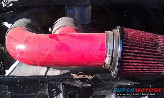 Red intake pipe with air filter attached, part of an engine
