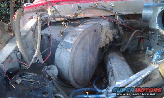 Engine bay showing AC box and wiring. Some hoses visible