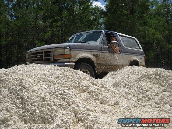 1994 Ford Bronco driving through a pile of light-colored gravel
