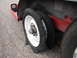 1992 Ford Taurus - A trailer's flat tire is severely damaged, with the rubber torn and exposed on the rim.