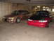 1992 Ford Taurus - Two Ford Taurus sedans, a red one with a black hood and a tan one, are parked side-by-side in a garage.