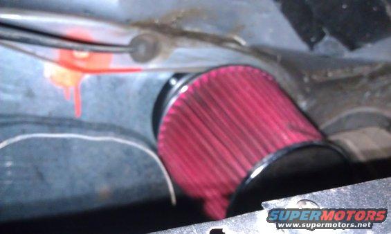 Red engine air filter installed in a vehicle's engine bay