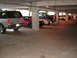 1992 Ford Taurus - Several cars are parked in a concrete parking garage, including an SUV, a red sedan, and a silver sedan.