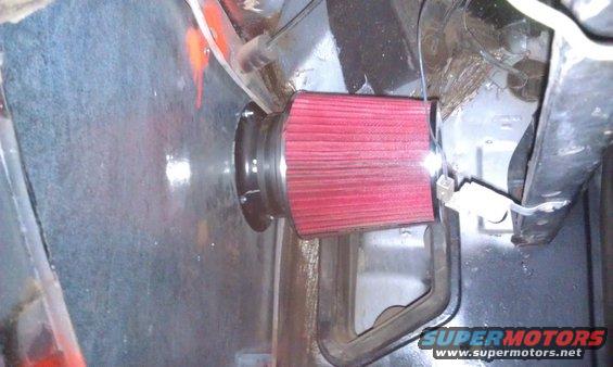 Red air filter installed in engine bay