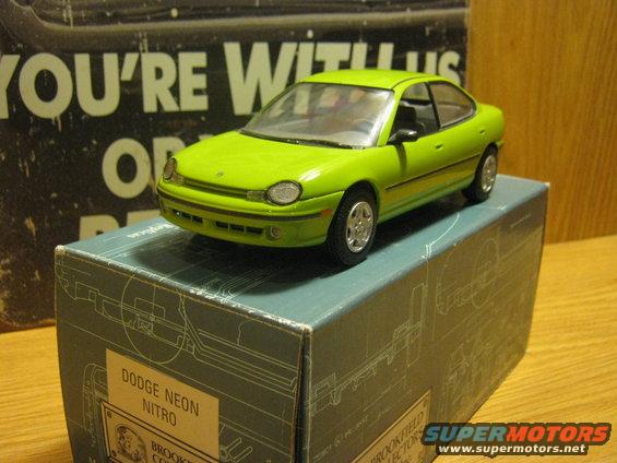 Green Dodge Neon Nitro model car on a box with diagrams. Front 3/4 view