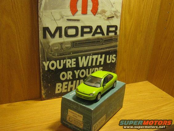 Lime green toy car on a box, with a Mopar sign in the background
