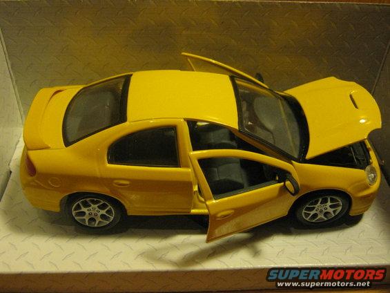 Yellow toy car with doors and hood open. It has a spoiler and custom wheels