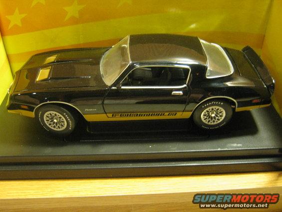 Black 1977 Pontiac Firebird Trans Am model car with gold trim and hood scoops, side view