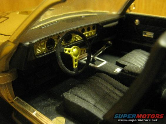 Gold and black car interior with bucket seats and a gold steering wheel