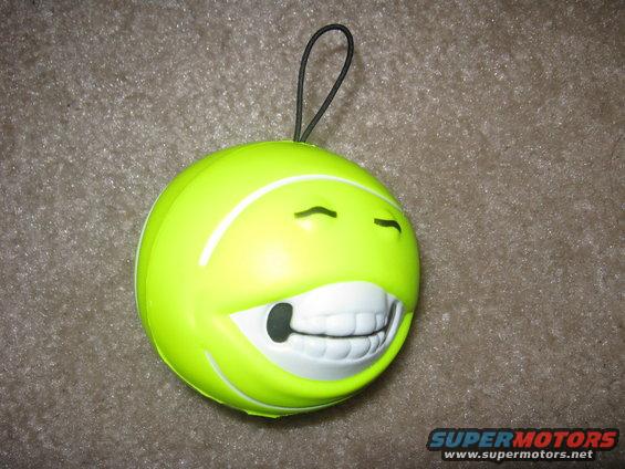 Yellow smiley face stress ball with a big grin and a loop for hanging
