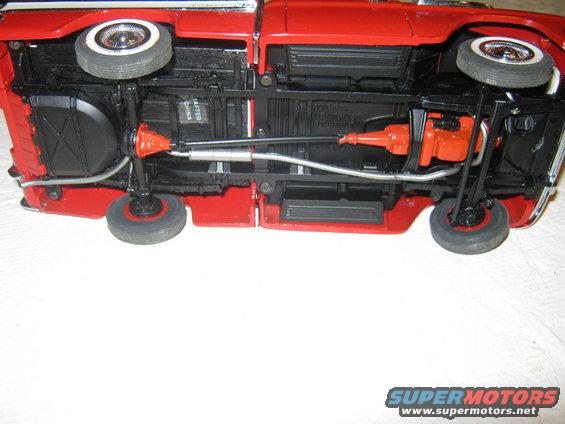 Underside of red toy car showing transmission and exhaust
