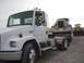 1959 Kenworth W900A - A white semi truck transports a vintage truck on a flatbed trailer, with a bulldozer visible behind them.