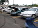 1992 Ford Taurus - Multiple Ford Taurus sedans are parked in a lot, with some hoods open, suggesting a car show or meet-up.