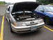 1992 Ford Taurus - The front of a 1992 Ford Taurus SHO is shown with its hood open, revealing the engine bay.