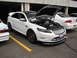 1992 Ford Taurus - A white sedan, likely a Ford Taurus from the 2010s, is parked with its hood open, revealing the engine compartment.