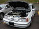 1992 Ford Taurus - A white 1992 Ford Taurus SHO is parked with its hood open, revealing the engine bay.