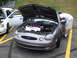 1992 Ford Taurus - A person inspects the engine of a gray Ford Taurus, parked next to a white car.