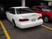 1992 Ford Taurus - Rear view of a white 1992 Ford Taurus sedan parked next to a red car.