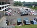 1992 Ford Taurus - A gathering of vehicles in a parking lot, with several hoods open, near a river and bridge.