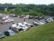 1992 Ford Taurus - A gathering of Ford Taurus sedans, some with hoods and trunks open, parked in an outdoor lot near a body of water.