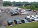 1992 Ford Taurus - A gathering of vehicles, including a 1992 Ford Taurus, with many hoods open at a car show event.