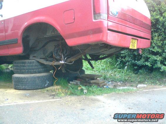 Rear axle and leaf springs of a red truck supported by tires
