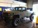 1983 Chevrolet C/K Pickup - This lifted pickup truck, painted in camouflage, is parked inside a garage with blue walls and white trim.