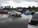 1992 Ford Taurus - A white 1992 Ford Taurus sedan is parked in a lot with other vehicles under a cloudy sky.