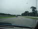 1992 Ford Taurus - Raindrops on the windshield obscure the view of cars driving on a wet racetrack.