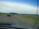 1992 Ford Taurus - Two cars are on a paved track with grass and fencing visible on the sides under a cloudy sky.