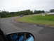 1992 Ford Taurus - A blue sedan drives on a race track under an overcast sky, with trees lining the course.