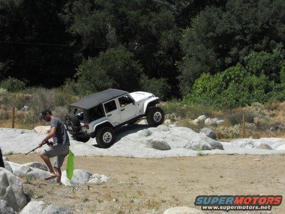 White Jeep Wrangler off-roading on rocks