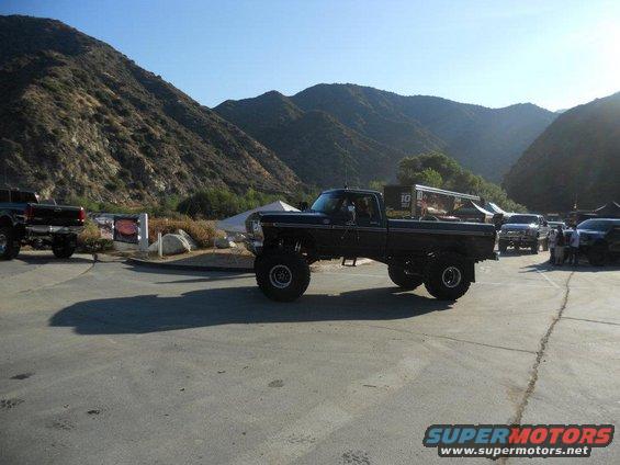 Lifted dark blue pickup truck, side view. Text on back reads '10'